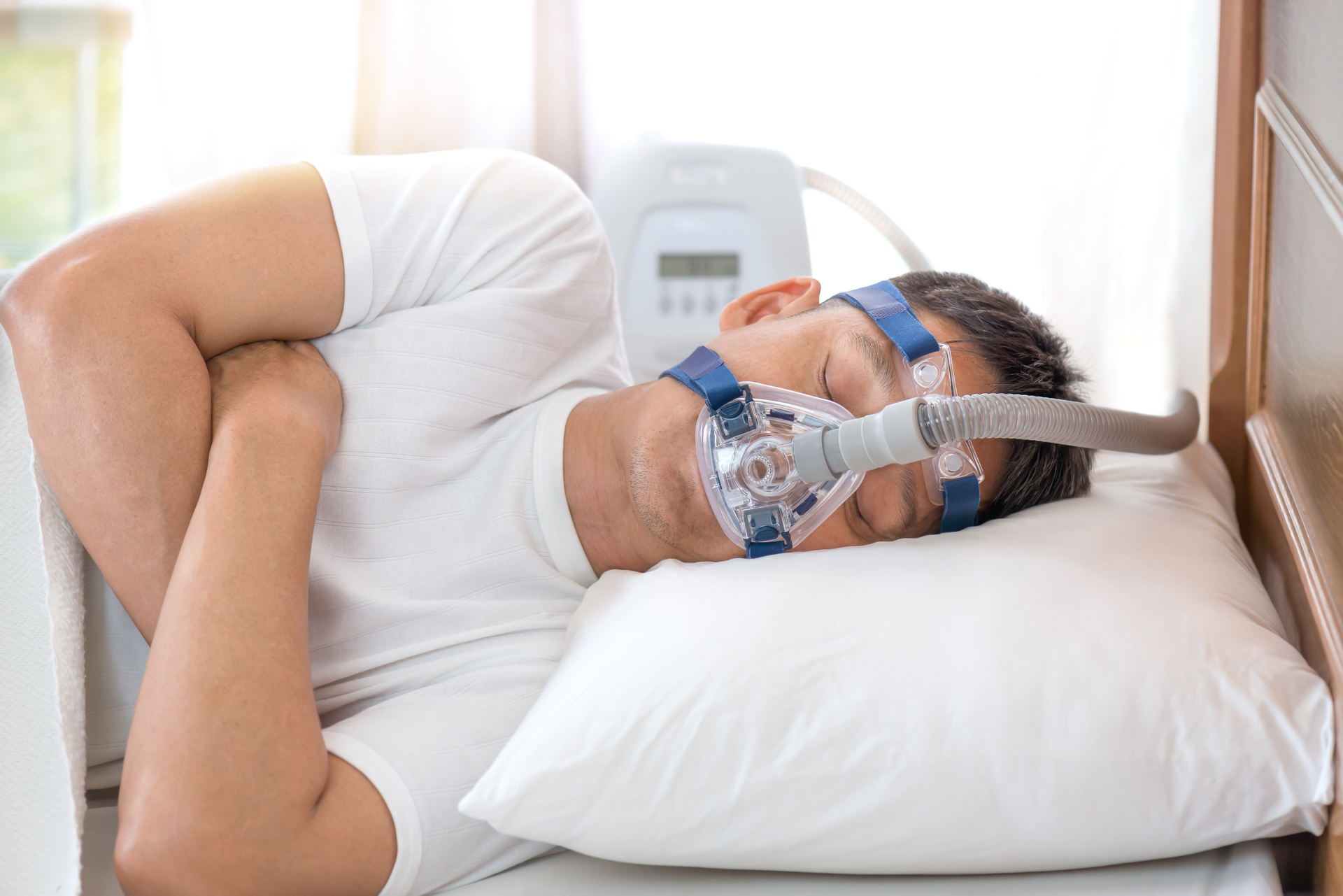 Man sleeping in bed wearing CPAP mask ,sleep apnea therapyHappy a man sleeping with a cpap mask