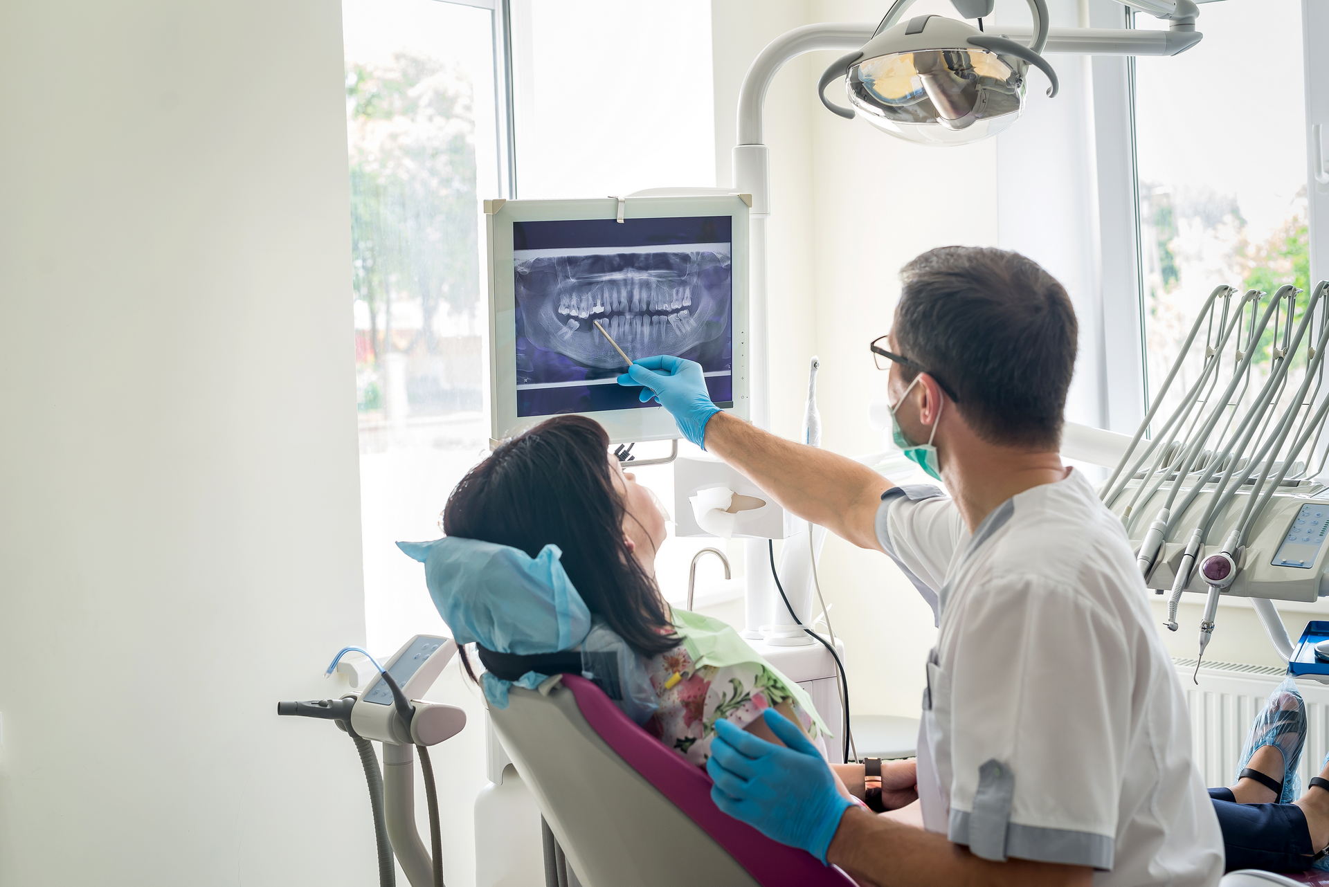 a dentist showing a patient x-ray